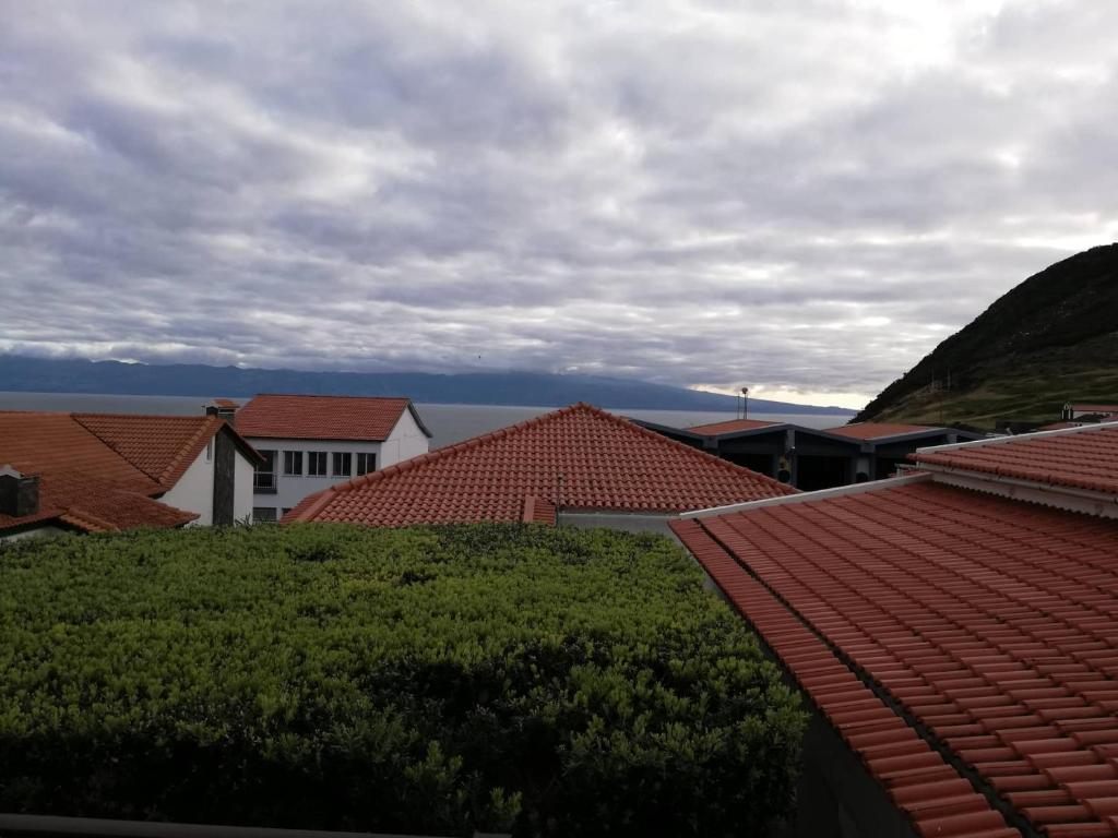 Green gardens and the ocean beyond the rooftops of Velas